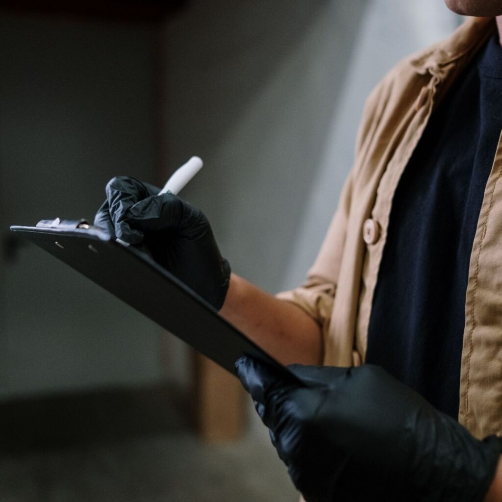Technician documenting findings during a professional mold inspection to evaluate moisture issues and determine the next steps.